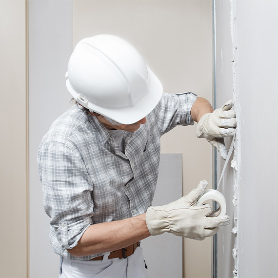 Man working on taping of drywall